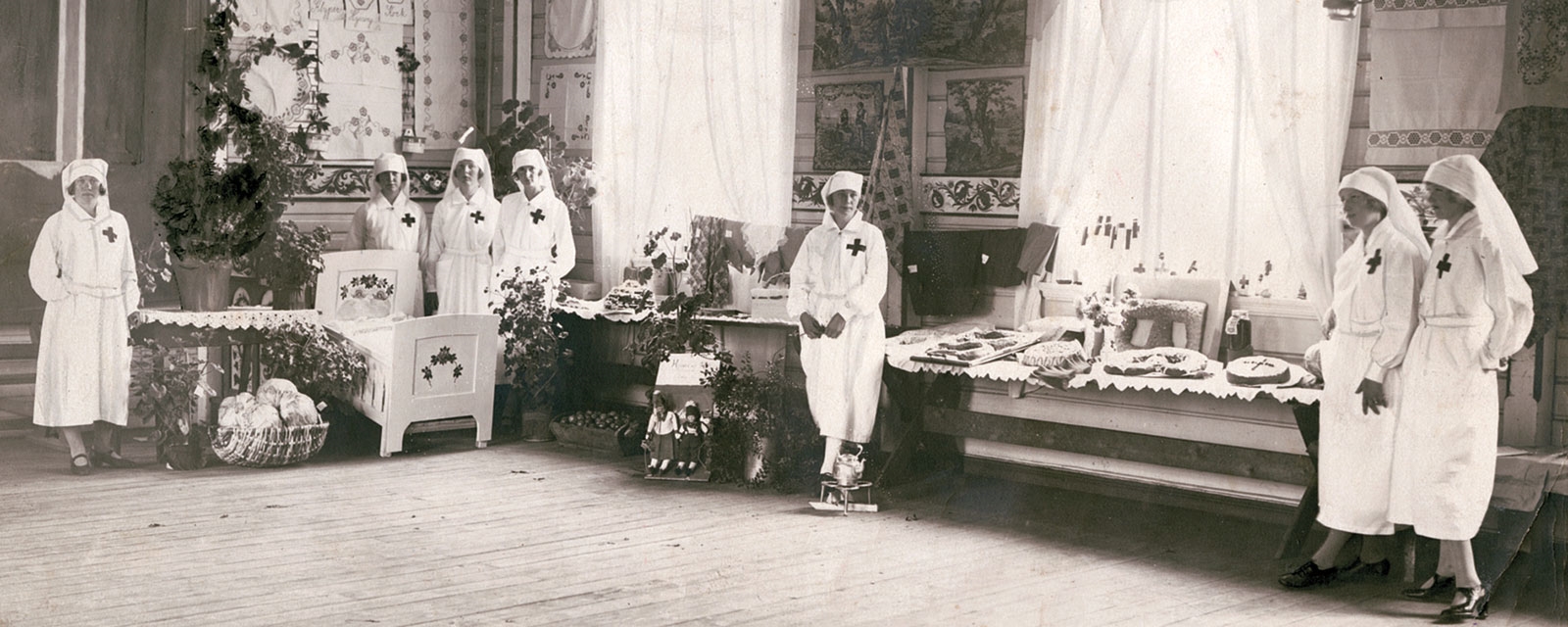 Gammelt foto av røde kors sykepleiere i hvite drakter med rødt kors på brystet