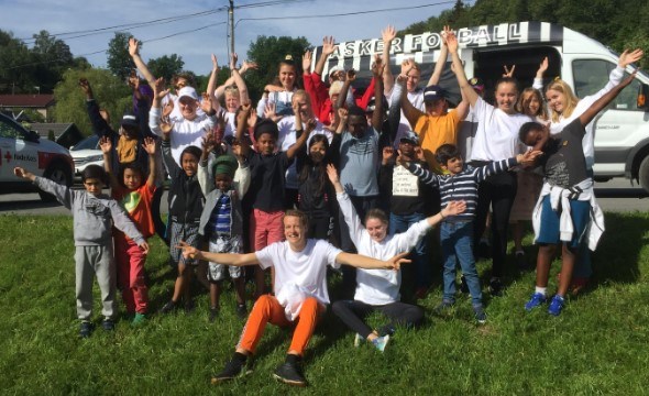 Bilde av alle barna som var med camp Solvik 2019 som alle vifter med armene.