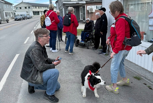 Mennesker ute på gåtur med en hund.