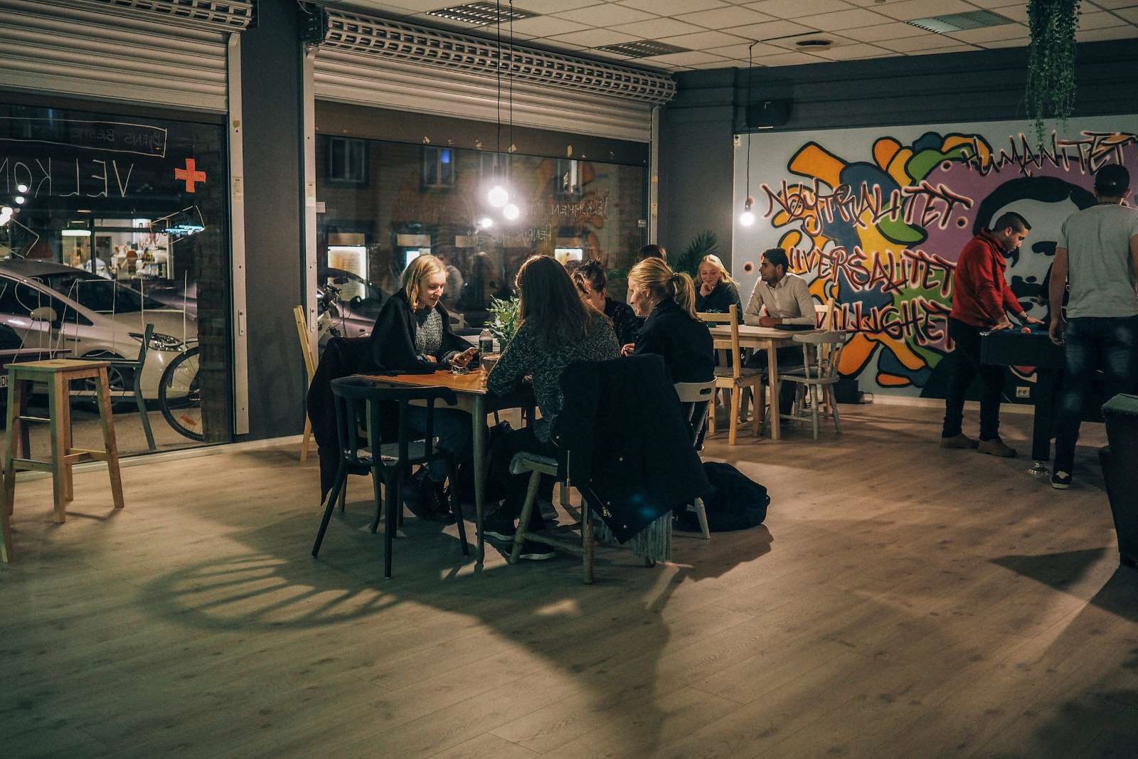 Ungdommer sitter rundt spisebord på kveldstid