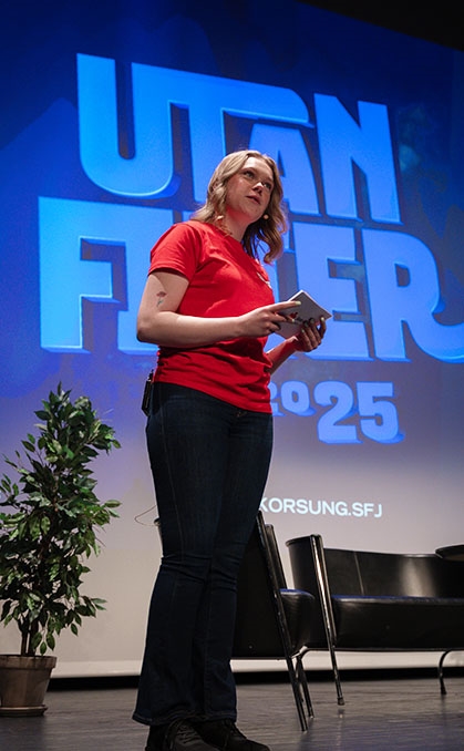 Ei jente står på scena og snakkar til publikum.