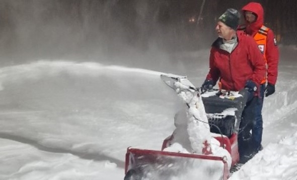 Røde kors-frivillige brøyter snø i uværet.