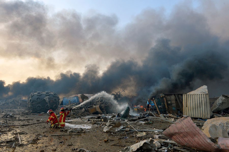 To brannfolk forsøker å slukke brann, enormt område i ruiner og sprengt bort
