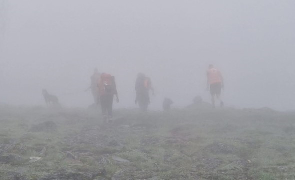 En gruppe frivillige går ute i tykk tåke og leter etter en savnet person.