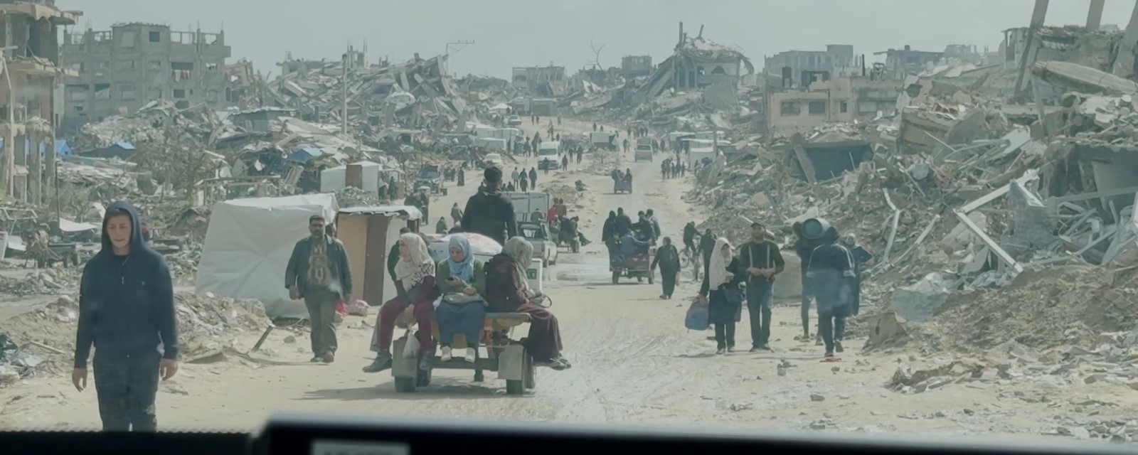 En bil kjører gjennom et utbombet boligområde i Gaza.