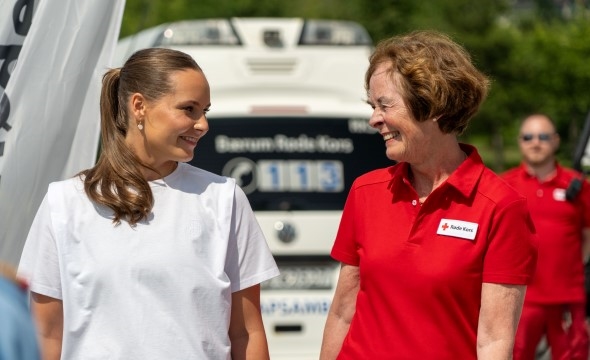 En yngre kvinne ser bort på en eldre kvinne og smiler.