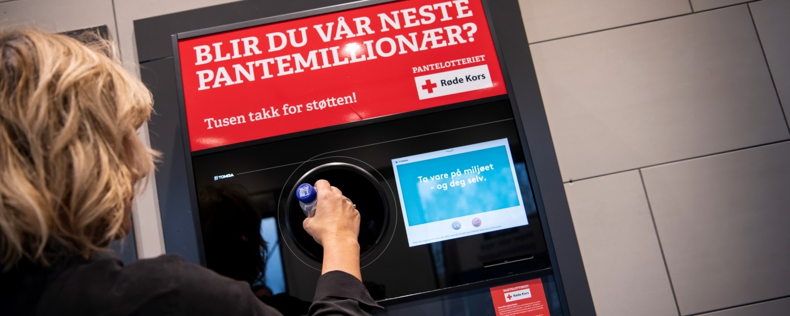 Person som putter flaske inn i panteautomat
