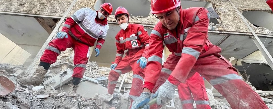 Frivillige graver i ruiner etter overlevende etter rakettangrep.