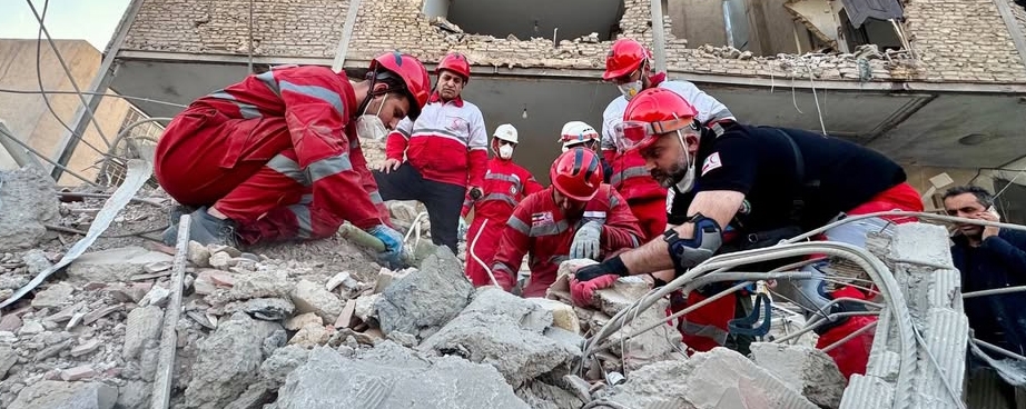 Frivillige graver i ruiner etter overlevende etter rekettangrep.