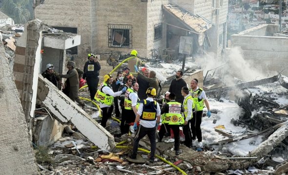 Mannskap fra Magen David Adom i Israel jobber i ruiner etter et rakrettangrep.