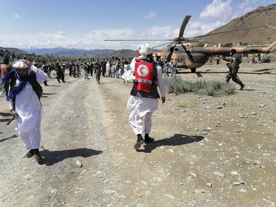 En mann fra Afghansk Røde Halvmåne går mot et helikopter.