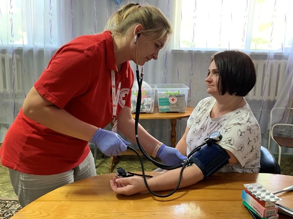 En helsearbeider måler blodtrykk på en kvinne