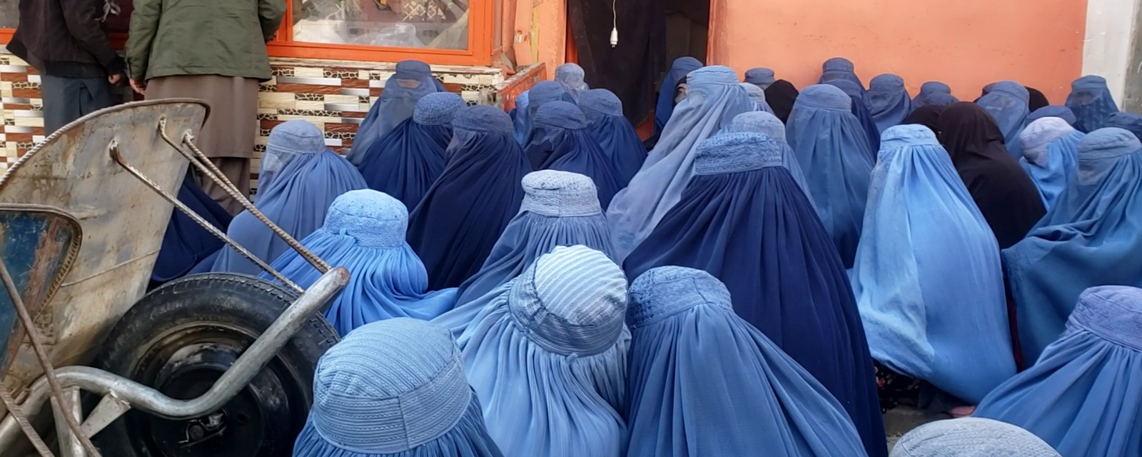 Afghanske kvinner venter foran et bakeri.