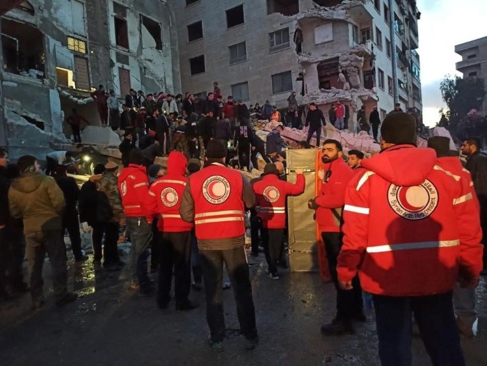 Mannskap fra Røde Kors deltar i redningsarbeid ved en sammenrast bygning