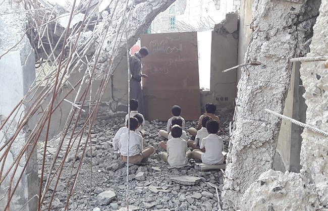 Barn får undervisning i et utbombet klasserom.