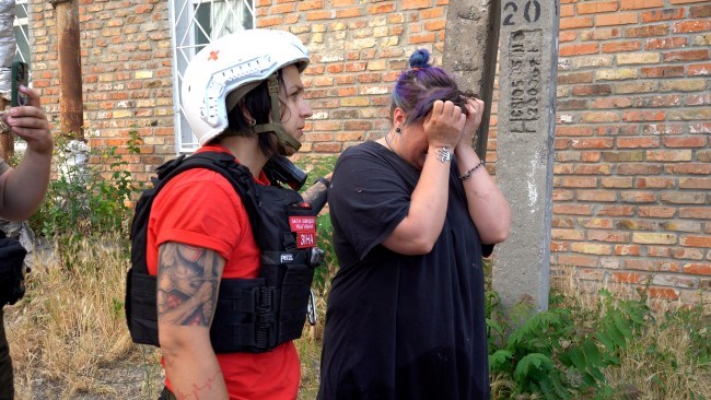 En frivillig fra Røde Kors trøster en kvinne som har blitt evakuert