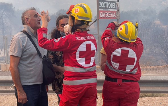 Røde Kors gir førstehjelp til folk rammet av skogbrann.