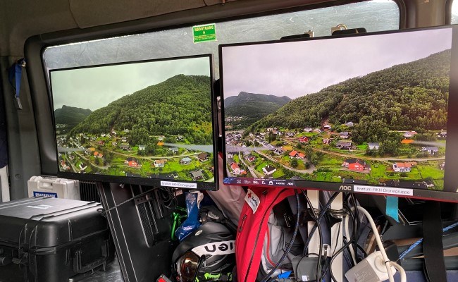 To skjermer som viser dronefilm