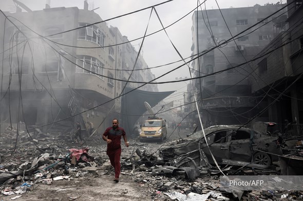 En mann løper etter et luftangrep på bygg i Gaza
