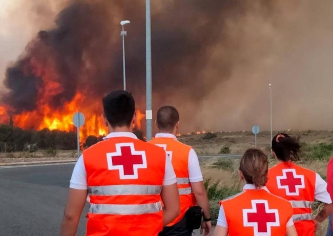 Røde Korspersonale ser på flammehav under en skogbrann i Spania