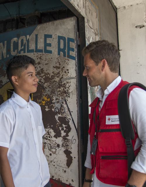 Ung mann snakker med Røde Kors delegat, El Savador