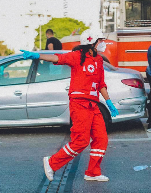 Kvinne i rød heldress og hvit hjem løper gjennom gate, Libanon Beirut, ute, dag, røyk