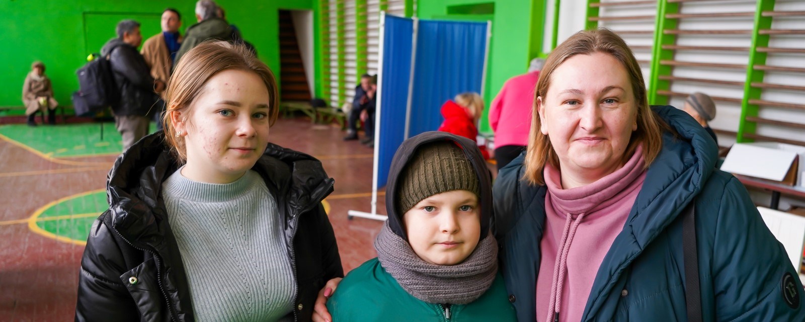 Tre personer ser i kamera i en gymsal utenfor Dnipro i Ukraina.