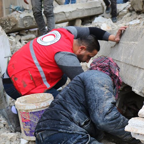 To mennesker graver i ruiner etter overlevende, syrisk røde halvmåne