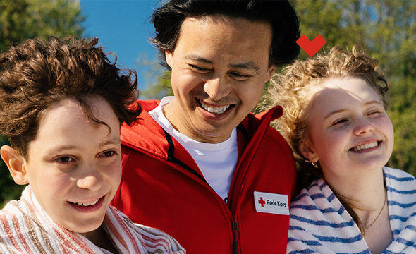 Barn på stranda smiler og klemmer.