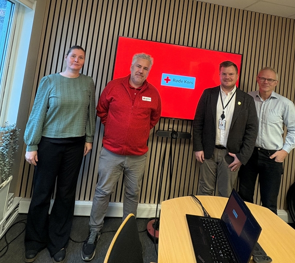 Samlet gruppe på fire ser i kamera