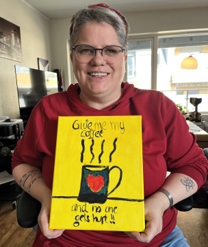 Besøksvert holder opp en plakat