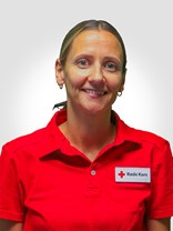 Portrett bilde av ei kvinne med langt brunt med lengde ned til nakken, bundet i en hestehale med strikk, to øredobber, et smått smil, med røde kors uniform på.