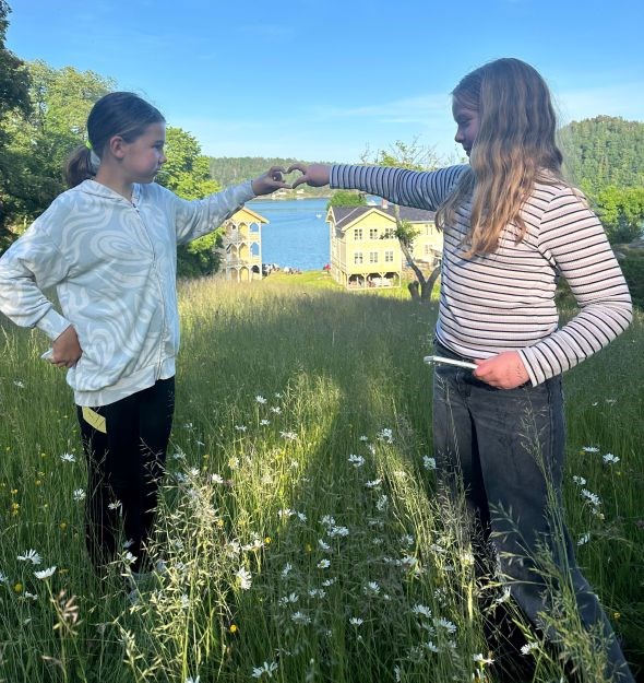 To jenter som symboliserer et hjerte med hendene sine