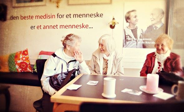 Tre eldre kvinner rundt et kafébord