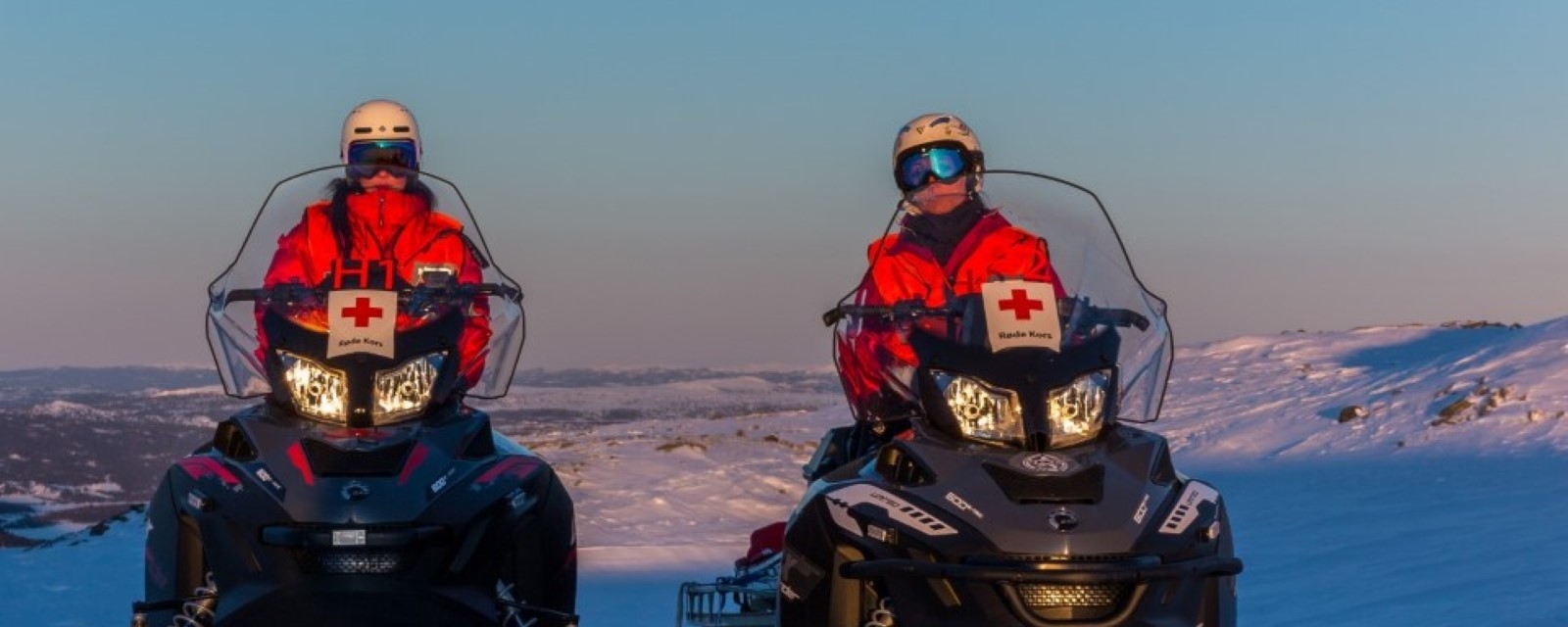  To kvinner fra Hjelpekorps sitter på hver sin scooter på fjellet