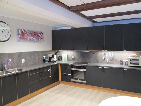 Kjøkkenkrok i svart med lys under skap