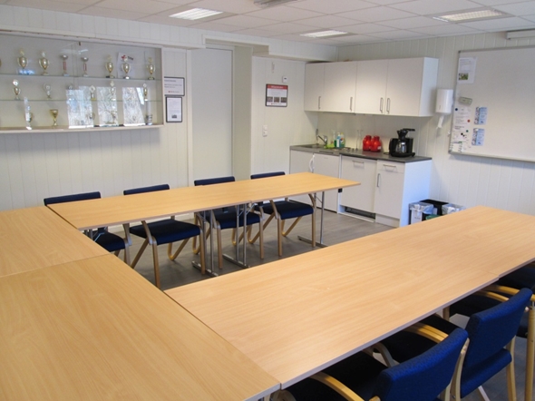 Et rom med bord, stoler og kjøkkenkrok