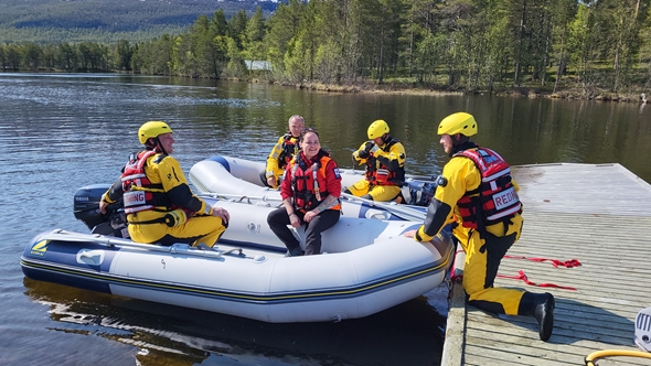 Flere mennesker rundt en redningsbåt