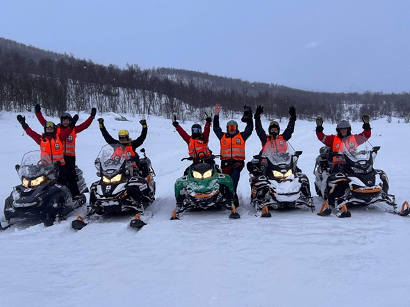 Frivillige fra Røde Kors og mange snøscootere i snøvær på fjellet
