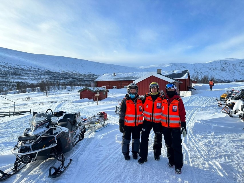 Tre hjelpekorpsere i uniform på fjellet.
