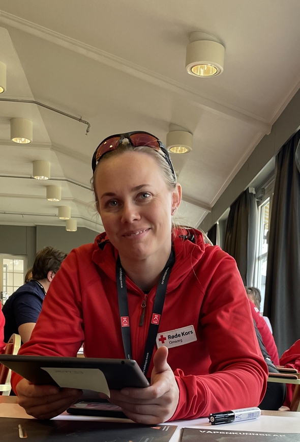 Kvinne smiler mot kamera