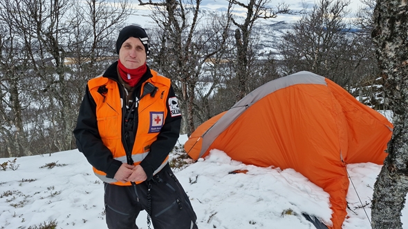 Foto av mann ute i vinterfjellet med hjelpekorpsklær