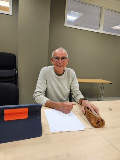 Mann som smiler mot kamera. Innendørsbilde