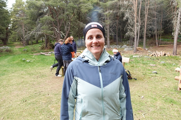 Kvinne som ser i kamera ute i skogen