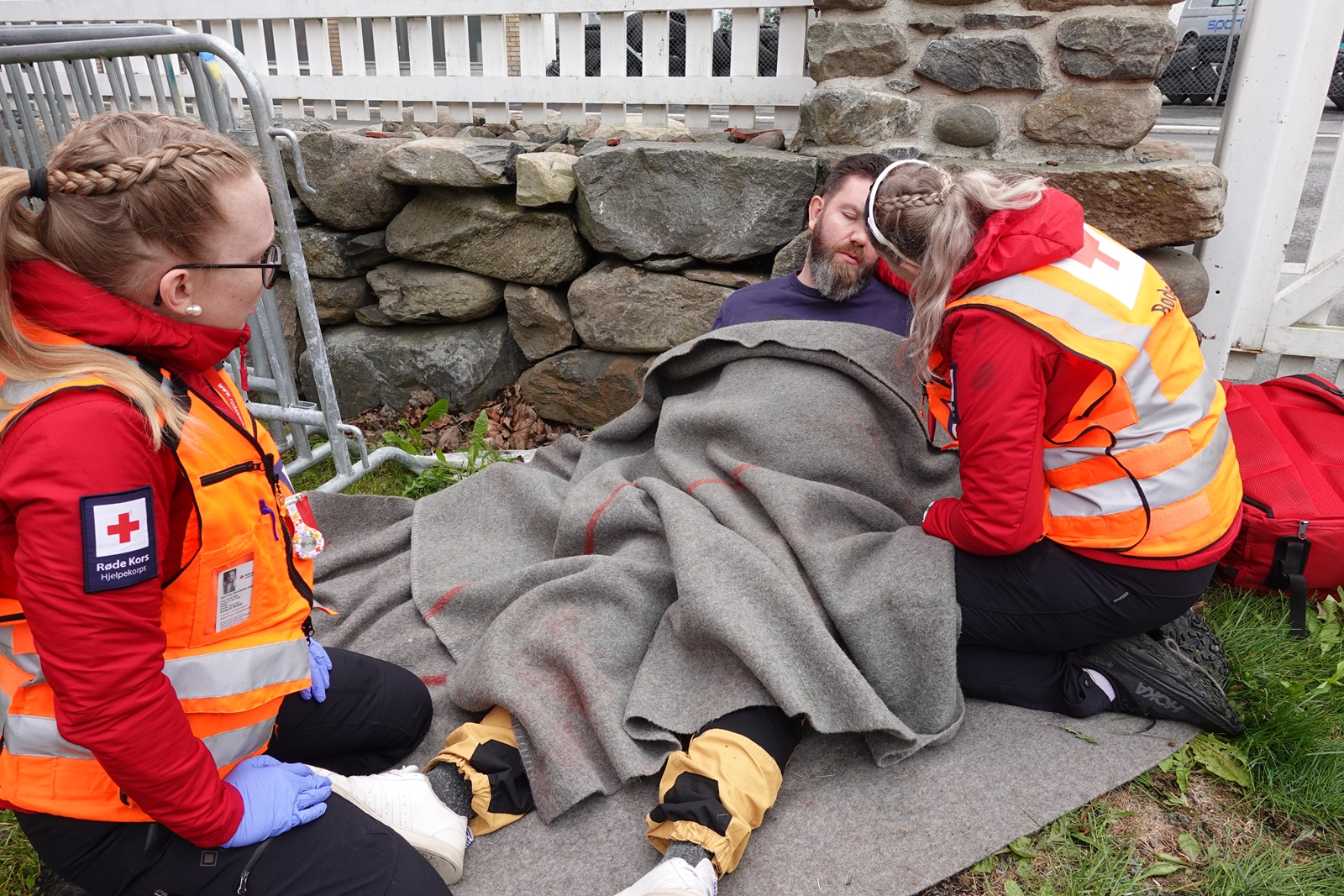 To hjelpekorpsere hjelper en mann som spiller full