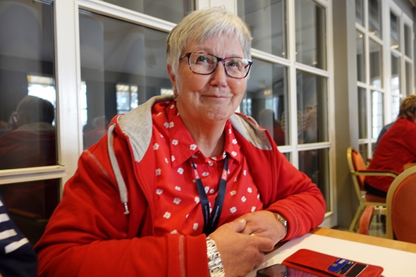 Kvinne smiler mot kamera i kursrom