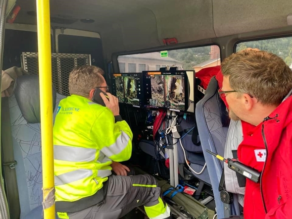 To menn som ser på bildene fra en drone.