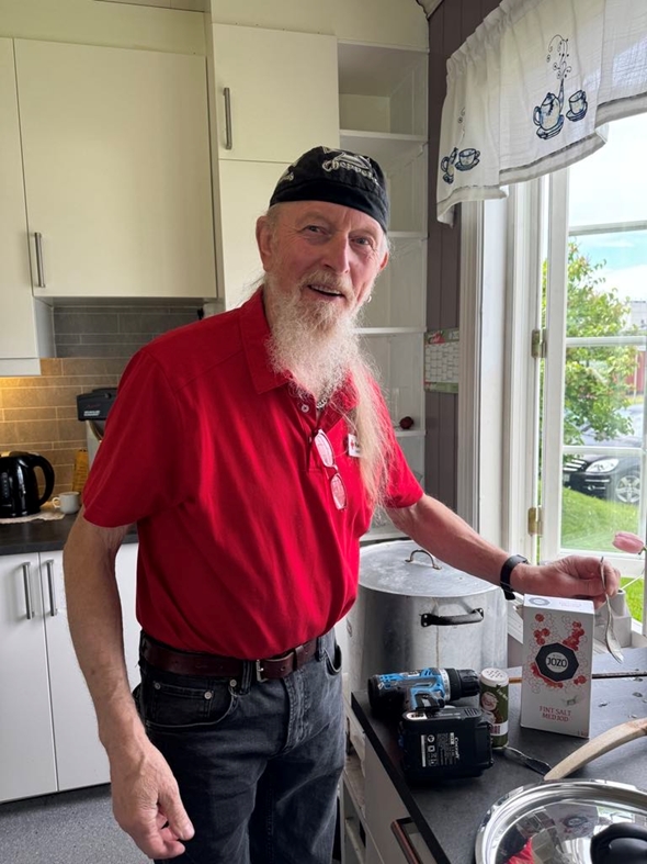 Mann i Røde Kors-klær på kjøkken