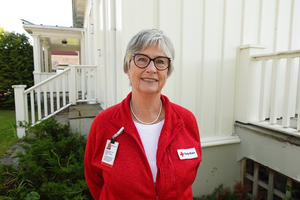 Kvinne i Røde Kors-klær smiler mot kamera