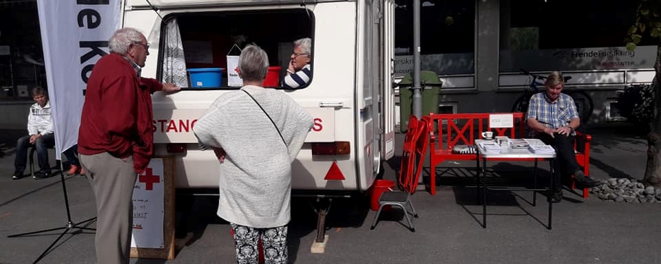 to personer foran røde kors bil